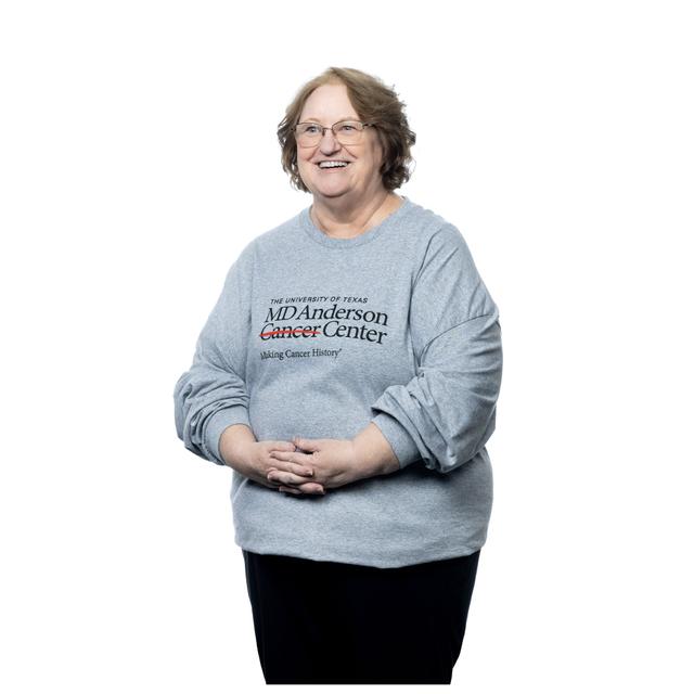 MD Anderson employee wearing grey t-shirt featuring the black MD Anderson logo on the chest area.