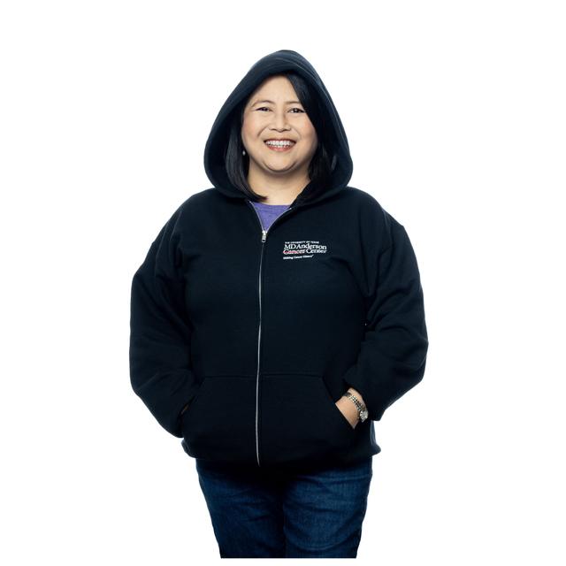 MD Anderson employee wearing a black zippered hoodie with pockets, featuring the white MD Anderson logo on the chest area.